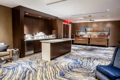 The Boerum — hotel lounge with dark wood paneling, blue seating, and back bar