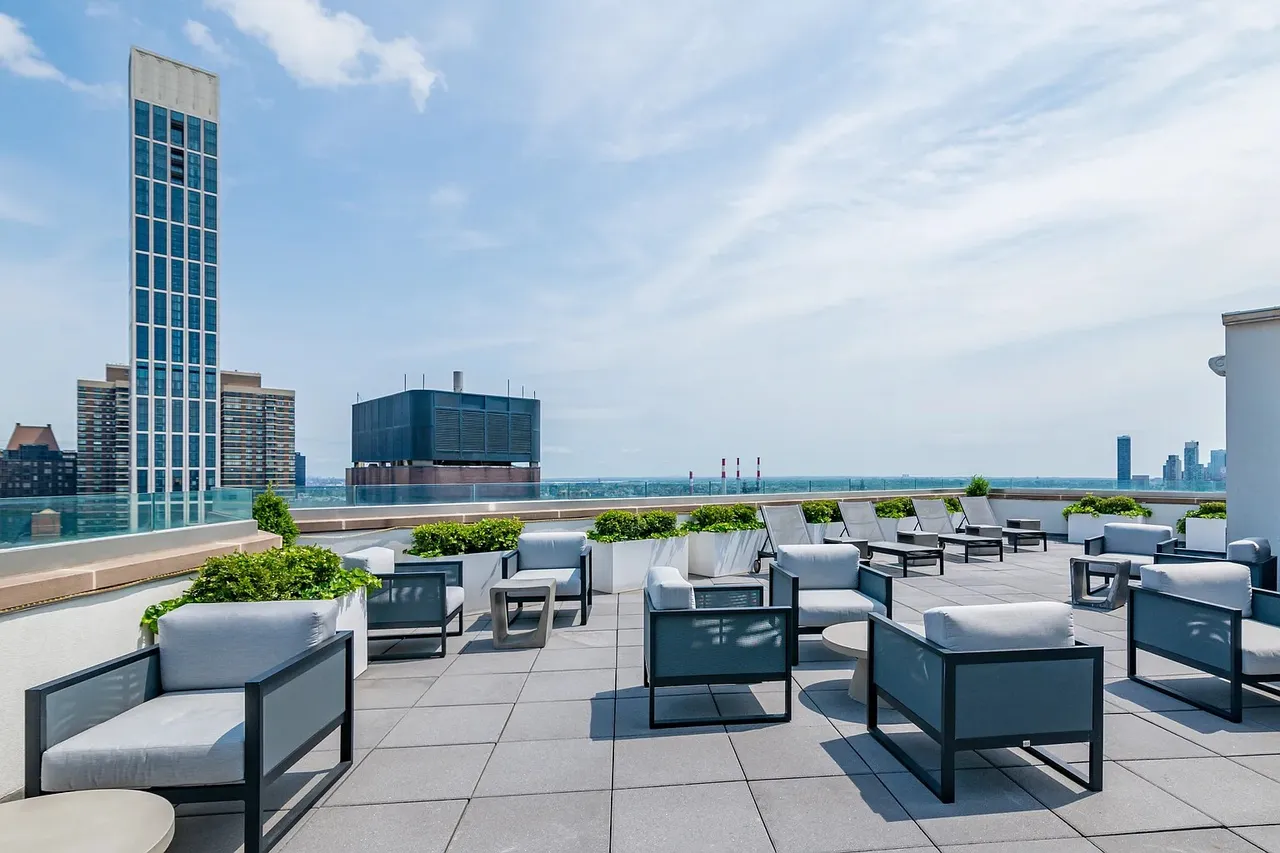 The Oriana — rooftop terrace amenity with lounge seating and Manhattan skyline view