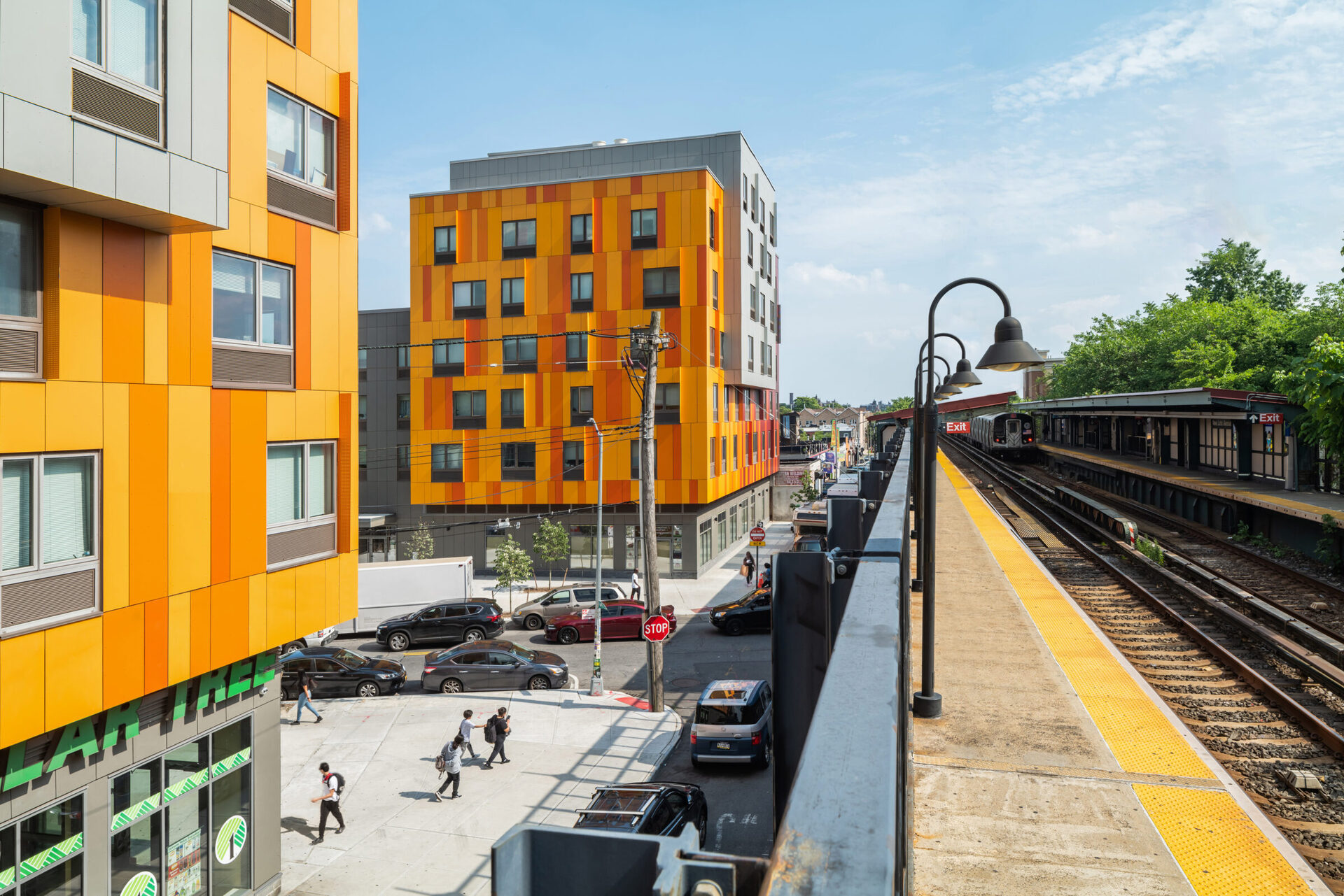 Van Sinderen Plaza — orange-paneled affordable housing development adjacent to elevated subway